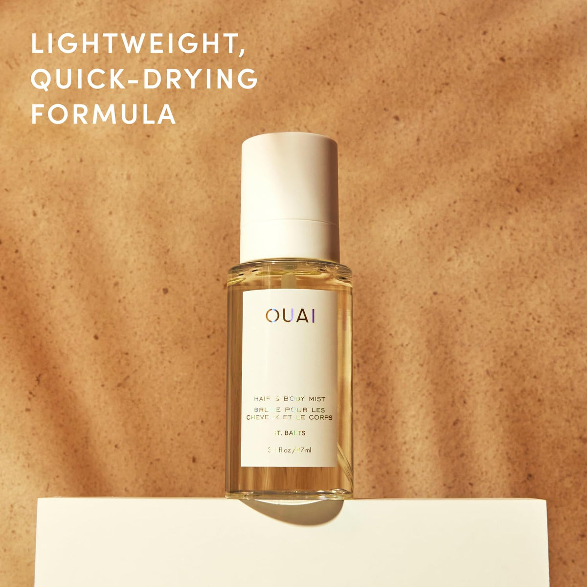 OUAI mist droplets on skin to show lightweight texture and non-greasy feel