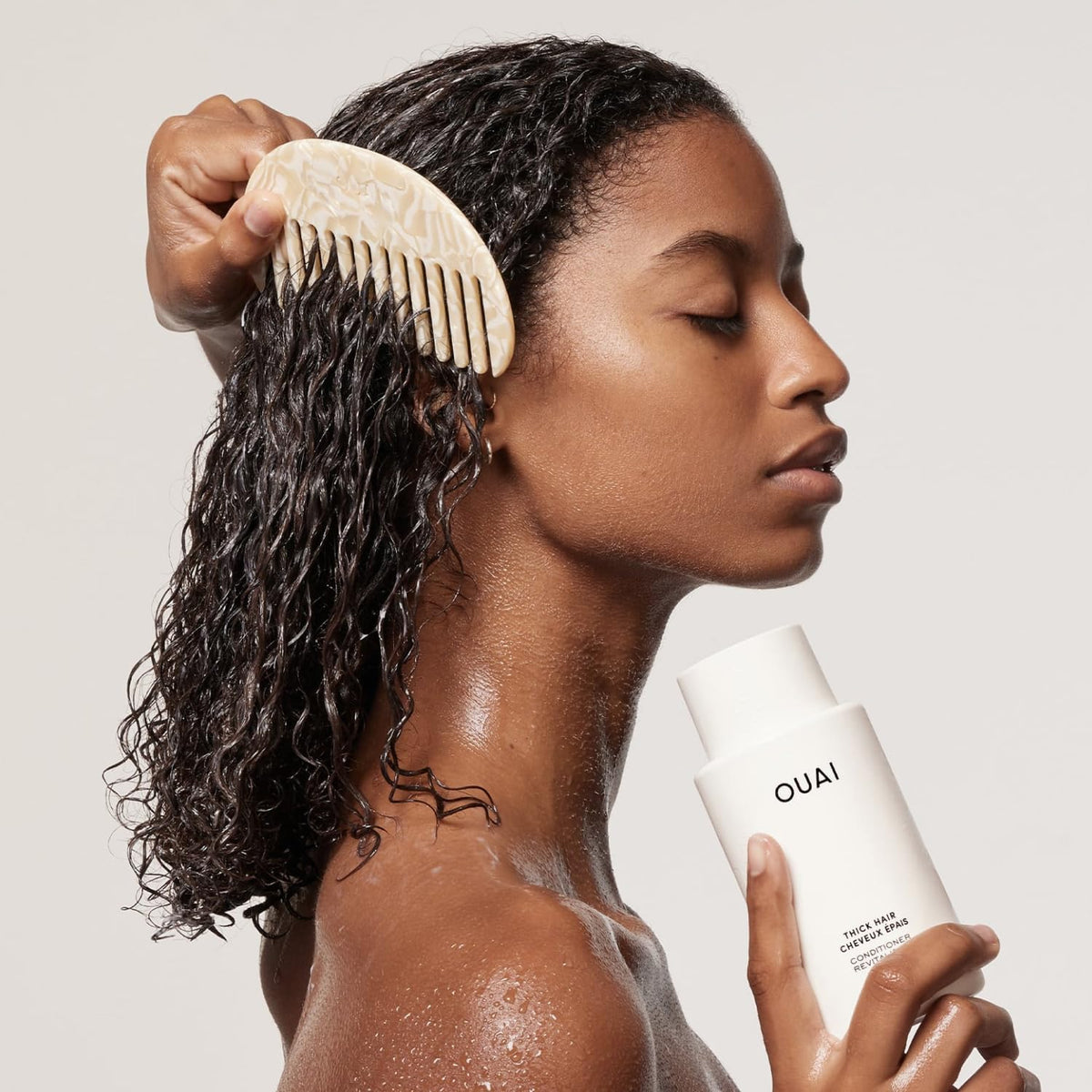 OUAI creamy conditioner texture on hand demonstrating rich slip