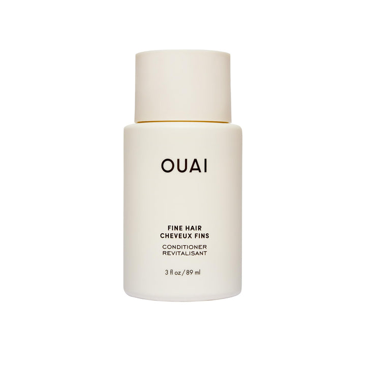OUAI travel bottle front view showing cleanser benefits and compact size