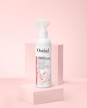 Ouidad bottle on bathroom shelf near styling tools to inspire daily curl routine