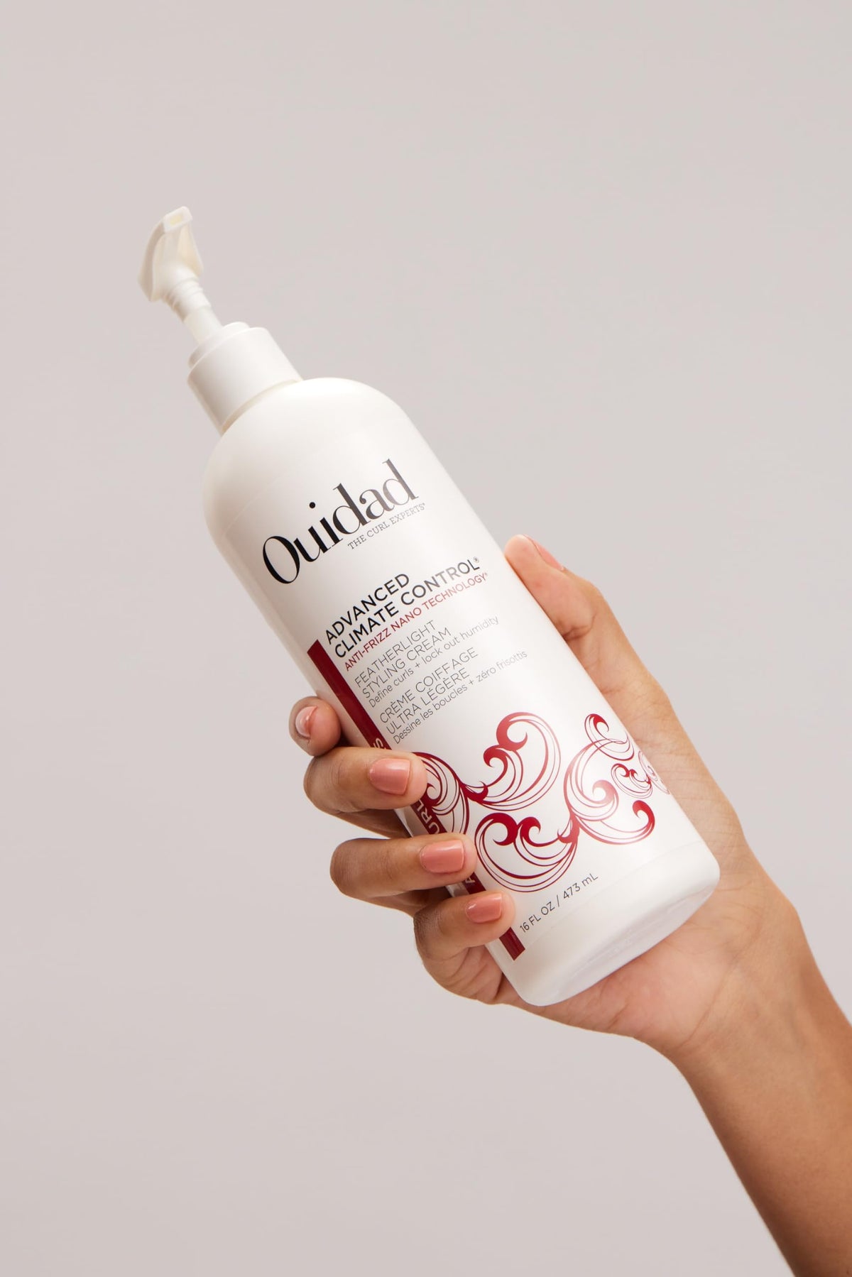 Ouidad size scale next to hand illustrates 16 fl oz volume