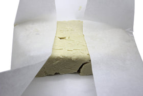 Our Earth's Secrets shea butter being scooped onto hand demonstrating smooth absorbency