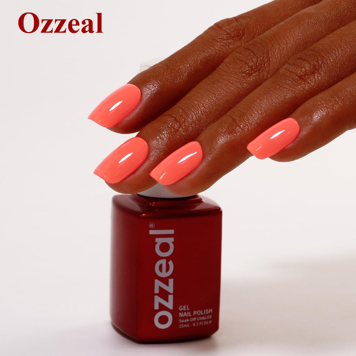 Ozzeal finished manicure on hand in natural light showcasing the coral shade as a fashion accent