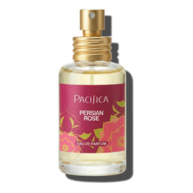 Pacifica Persian Rose bottle on vanity among flowers, evokes romantic everyday elegance
