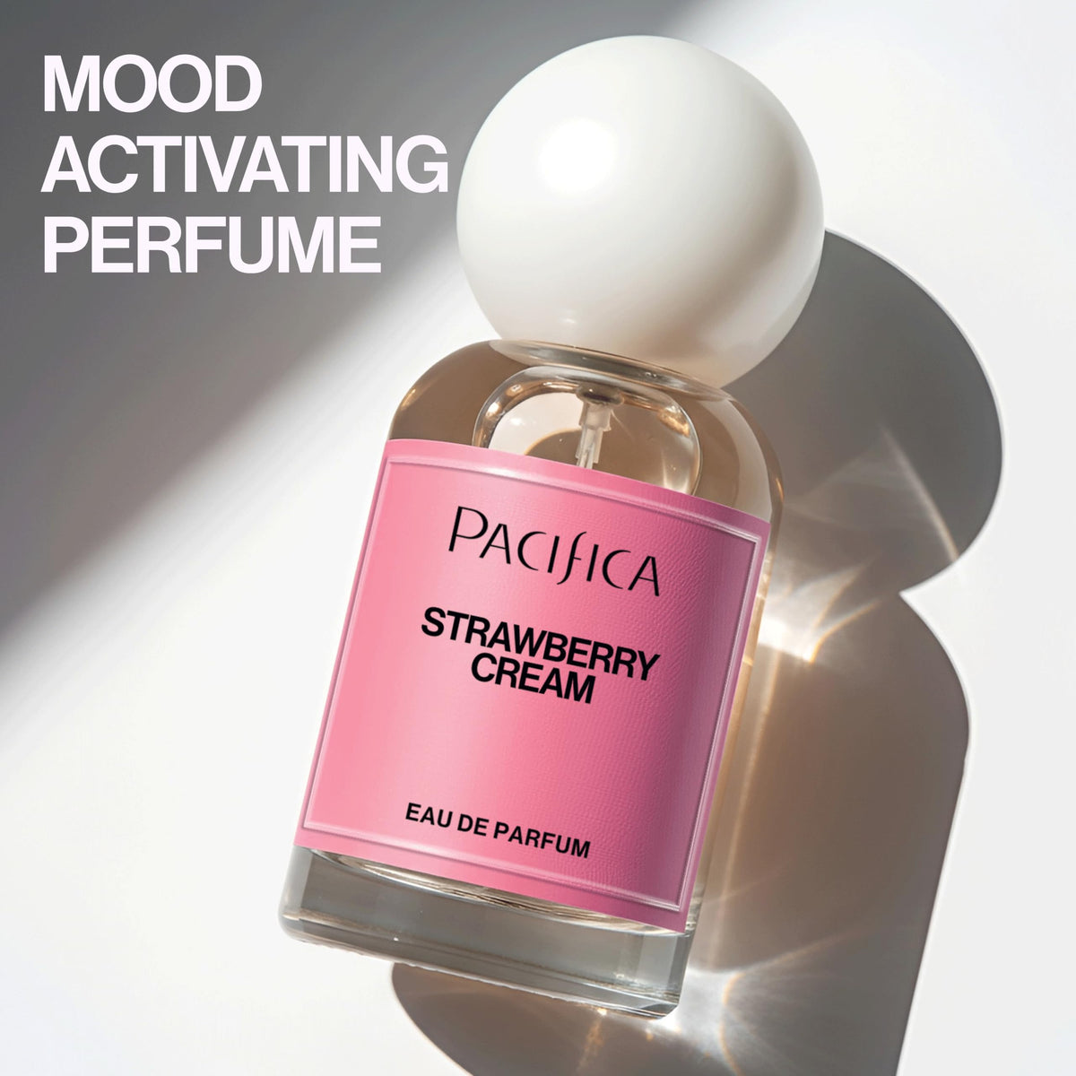Pacifica bottle beside fresh strawberries illustrating fruity notes and inviting gourmand appeal