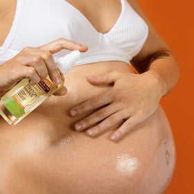 Palmer's being applied to a pregnant belly demonstrating soothing hydration