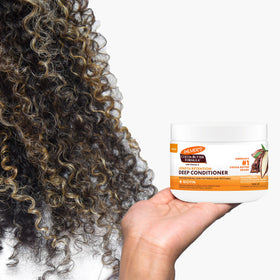 Palmer's conditioner being applied to hands ready to detangle and nourish
