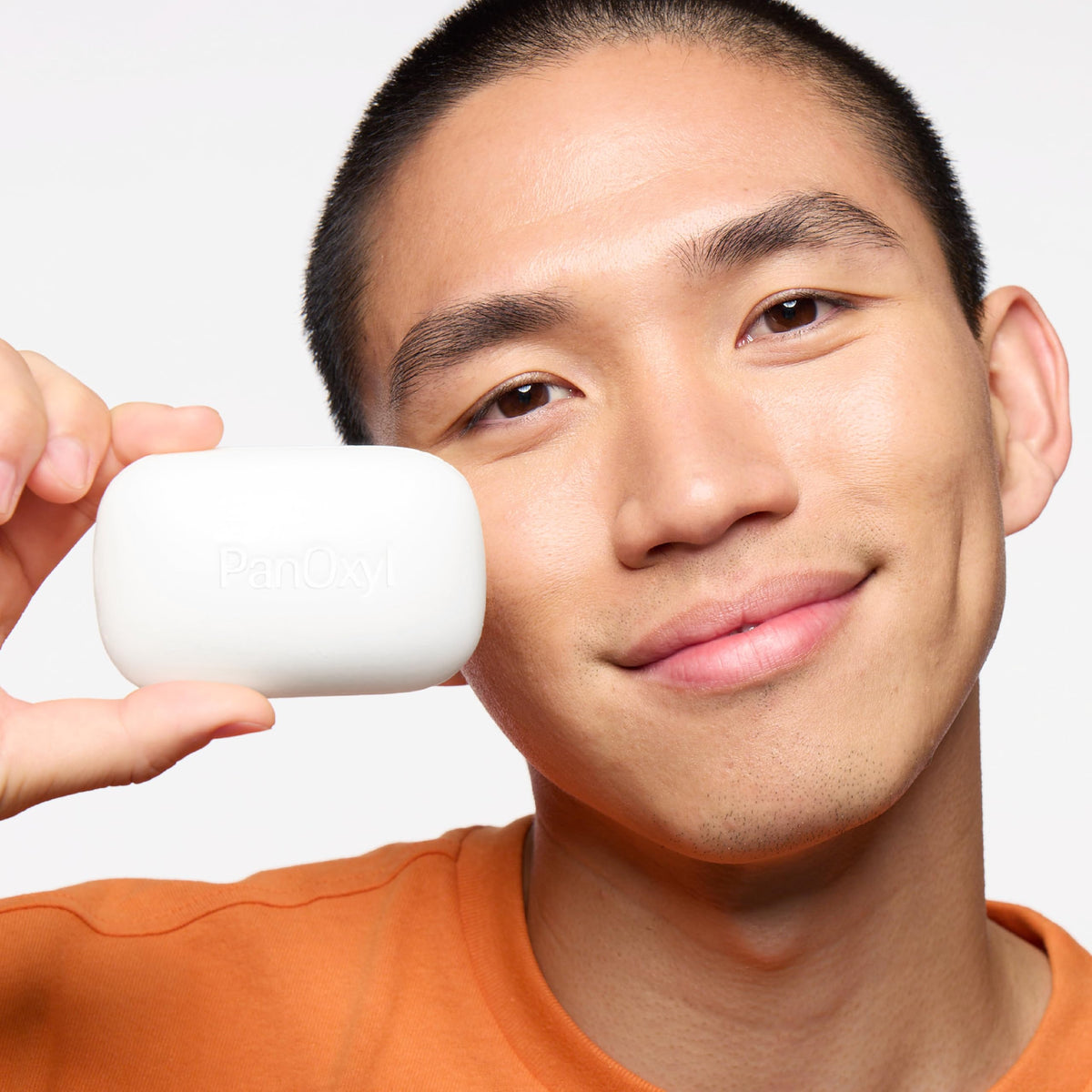 PanOxyl applied to face at mirror showing targeted acne treatment use