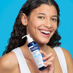 PanOxyl bottle next to smartphone to show scale and travel-friendly size