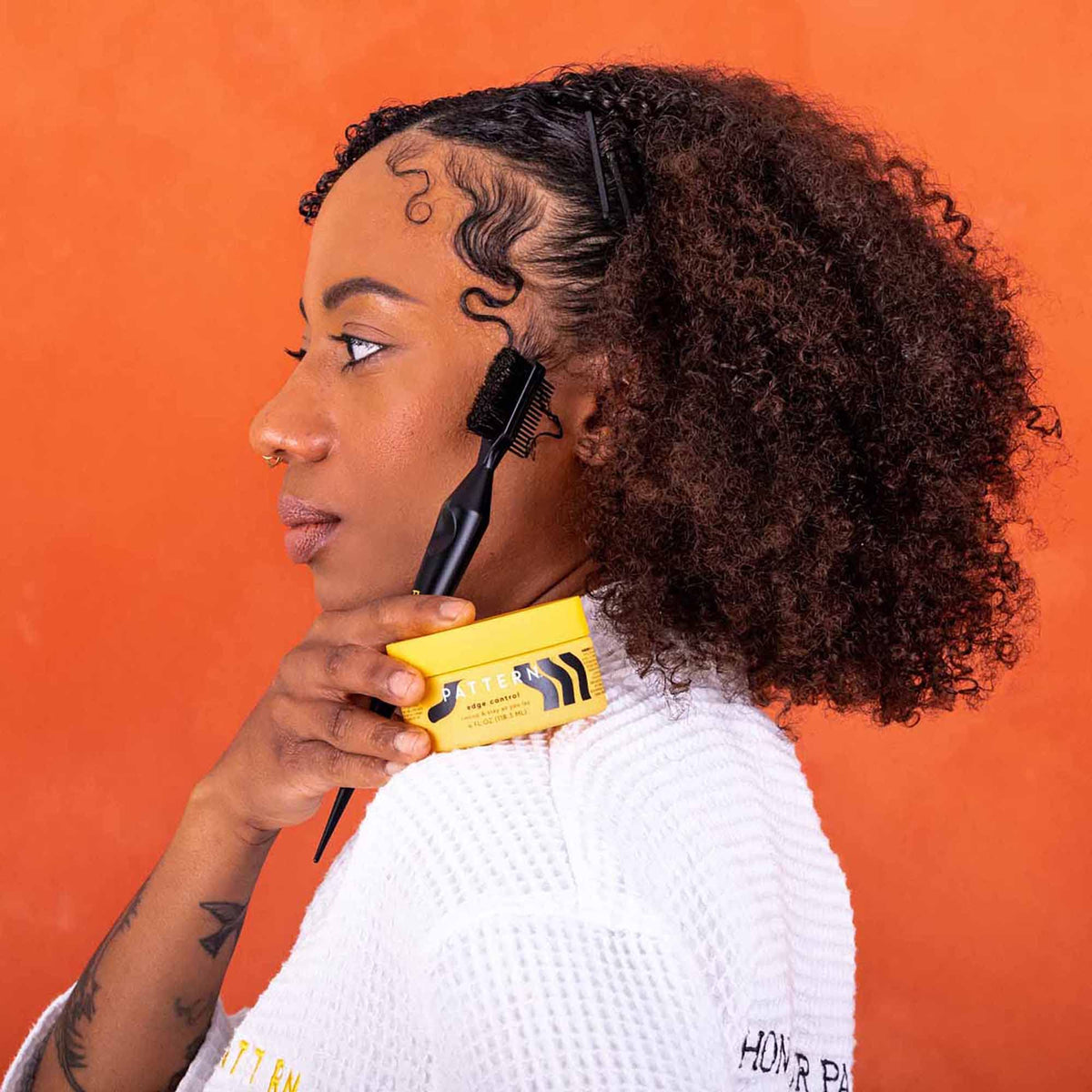 PATTERN edge control being applied with small brush for precise, gentle styling at hairline