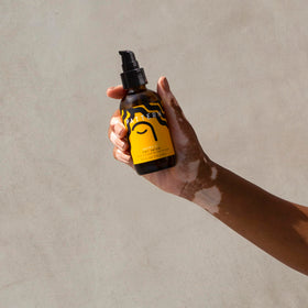 PATTERN massaging serum into scalp to soothe dryness and flaking
