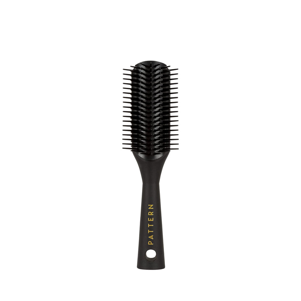 PATTERN mini shower brush front view showing compact shape and ergonomic handle for easy control