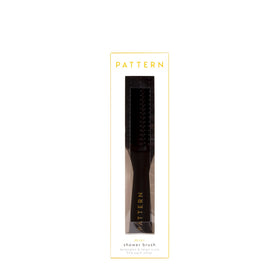 PATTERN brush next to hand to show travel-friendly size and convenient portability