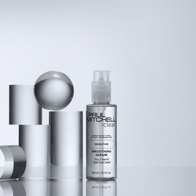Paul Mitchell applying serum to damp hair for faster blow‑drying