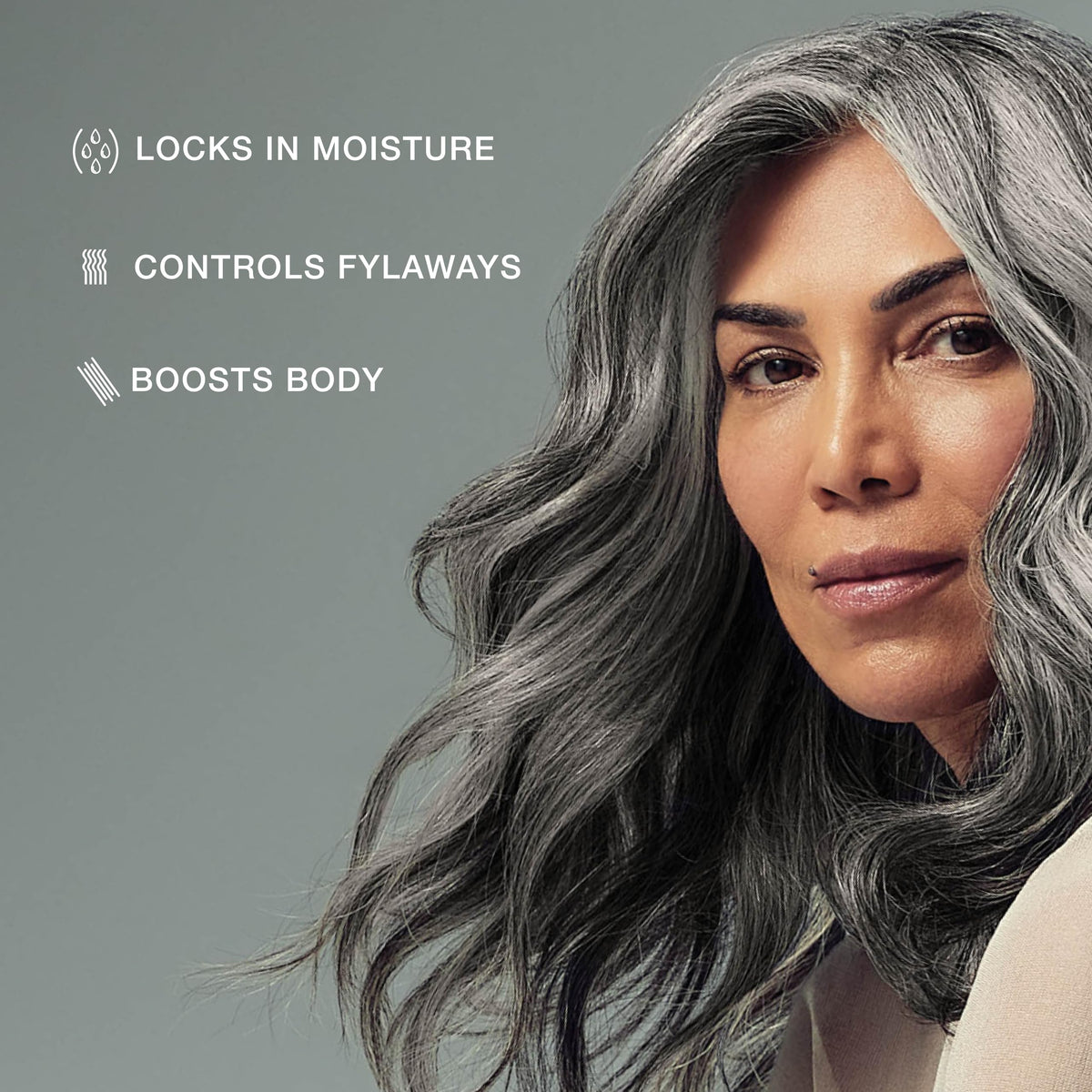 Stylist applying Paul Mitchell foam to damp hair for structured blowout