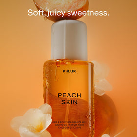 PHLUR bottle spraying mist in air highlighting Peach Skin application benefit: fine even distribution