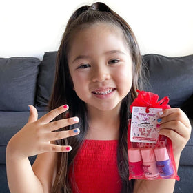 Child's fingernails being painted with Piggy Paint by parent — low odor and family friendly