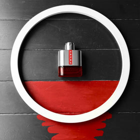 Prada Luna Rossa Sport next to a passport for travel-friendly 100 ml convenience