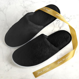 QatmMkt slippers beside guest bed signaling ready-for-guests comfort
