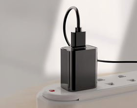 Qjin adapter beside a coin for scale, compact travel-friendly size
