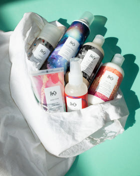 R+Co Hot Spell balm being placed into palm before styling, demonstrates simple application benefit