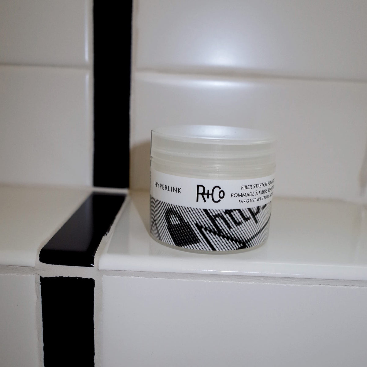 R+Co Hyperlink size comparison next to hands illustrating compact travel-friendly jar