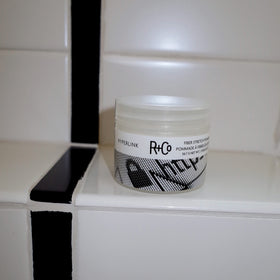 R+Co Hyperlink size comparison next to hands illustrating compact travel-friendly jar