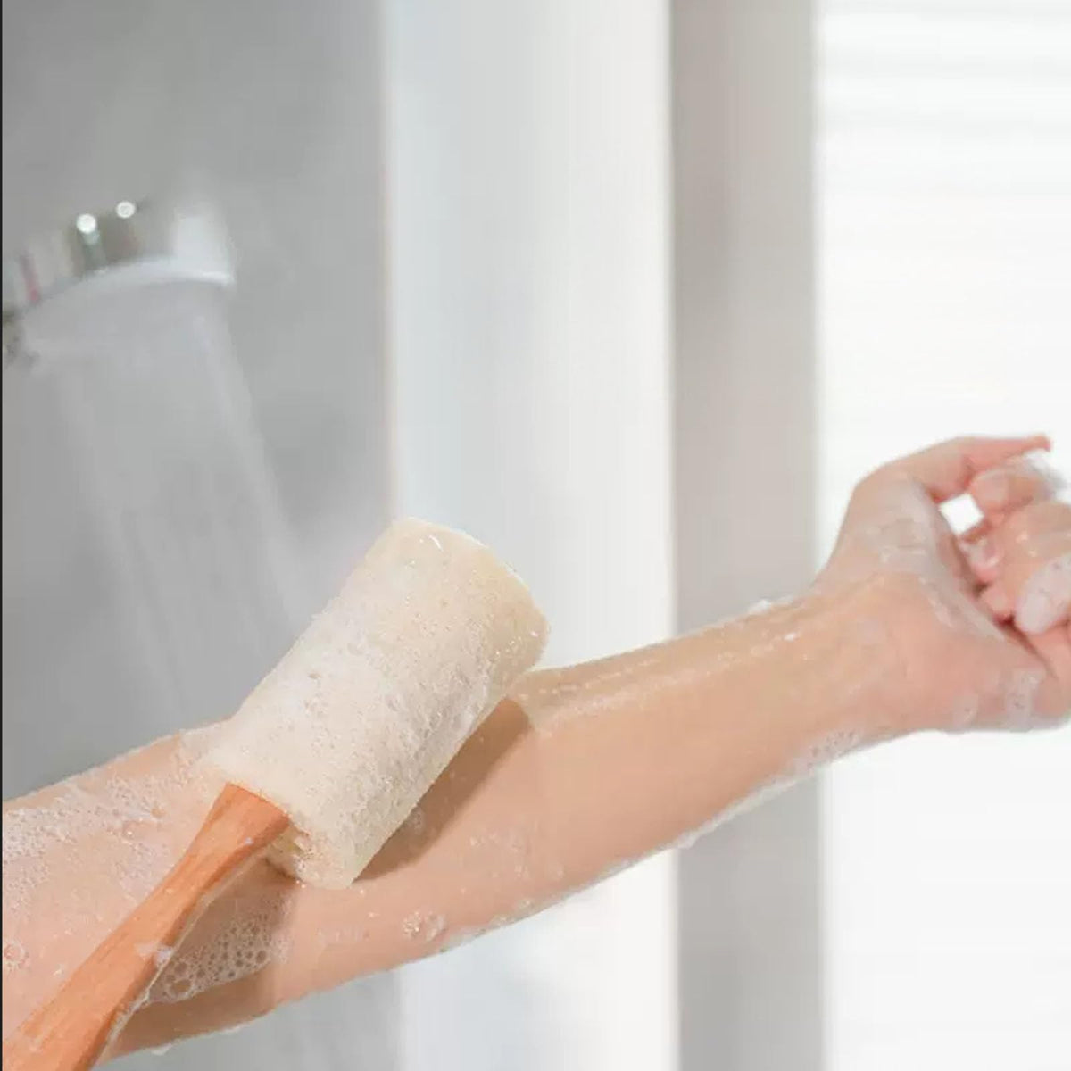 Rainlily Wen sponge held in hand to show scale and ergonomic handle advantage