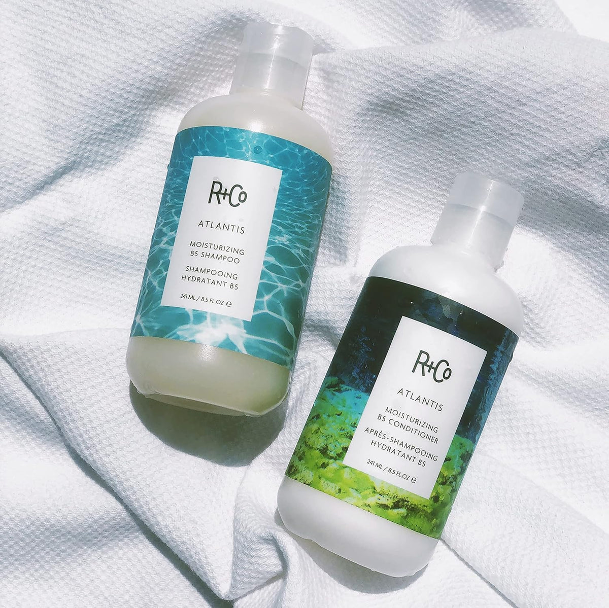 R+Co Atlantis bottle next to everyday objects showing true 8.5oz scale