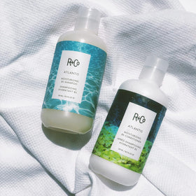 R+Co Atlantis bottle next to everyday objects showing true 8.5oz scale
