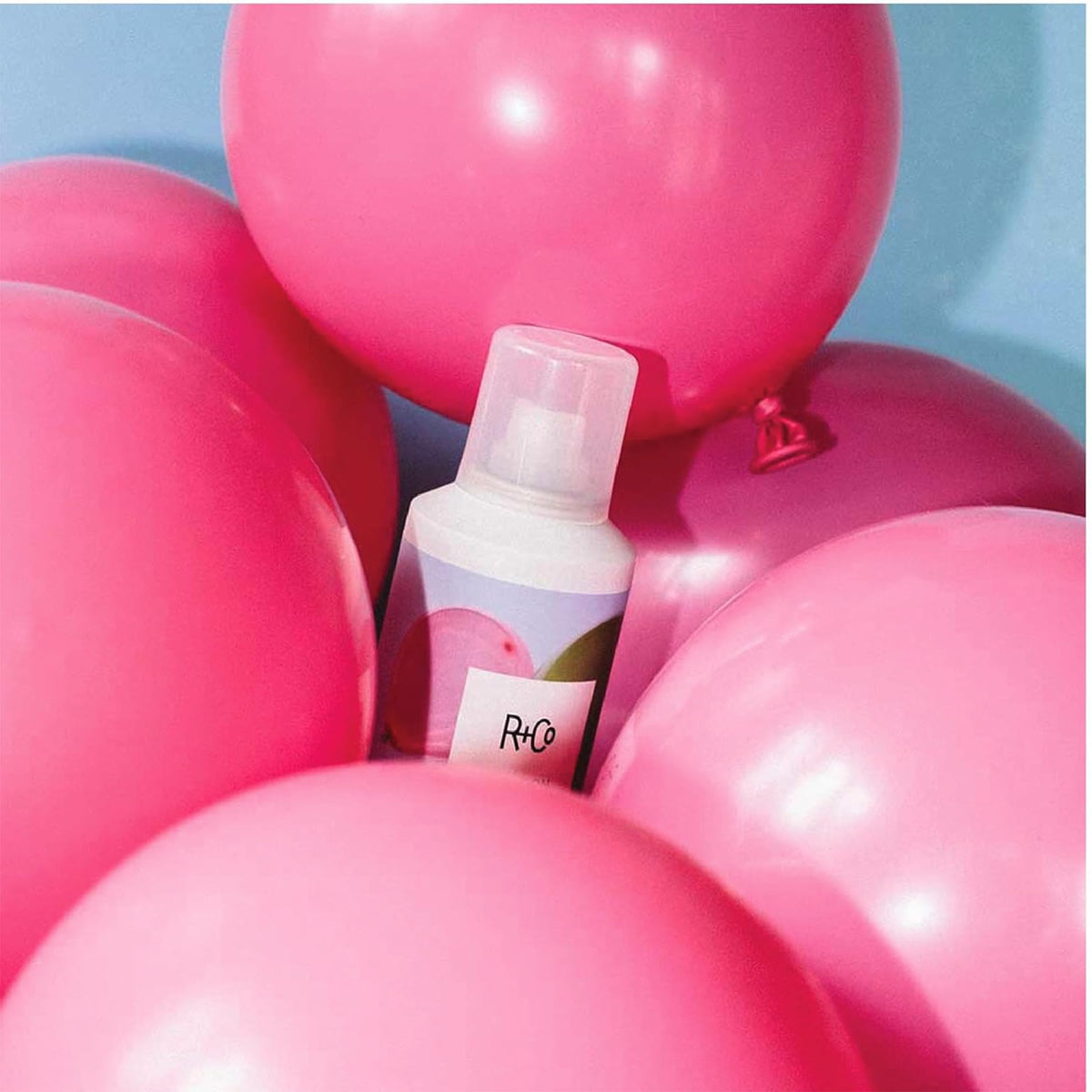 R+Co spray in hand to show 5oz scale and travel-friendly convenience benefit