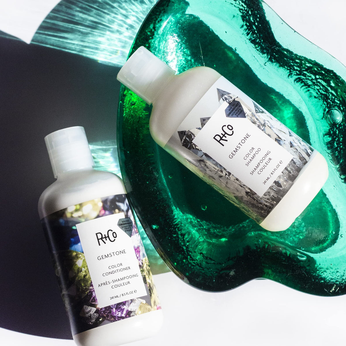 R+Co Gemstone bottle beside colored hair strand displaying enhanced shine