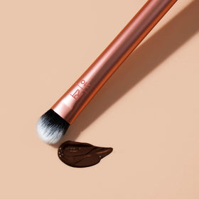 Real Techniques brush dotting concealer on blemish for concealment