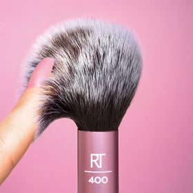 Real Techniques brush with cream blush swatch demonstrating compatibility with cream formulas