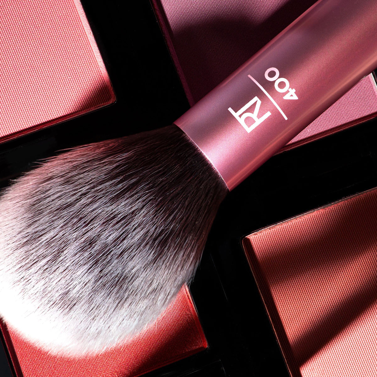 Real Techniques brush resting on powder pan showing pickup and distribution benefit
