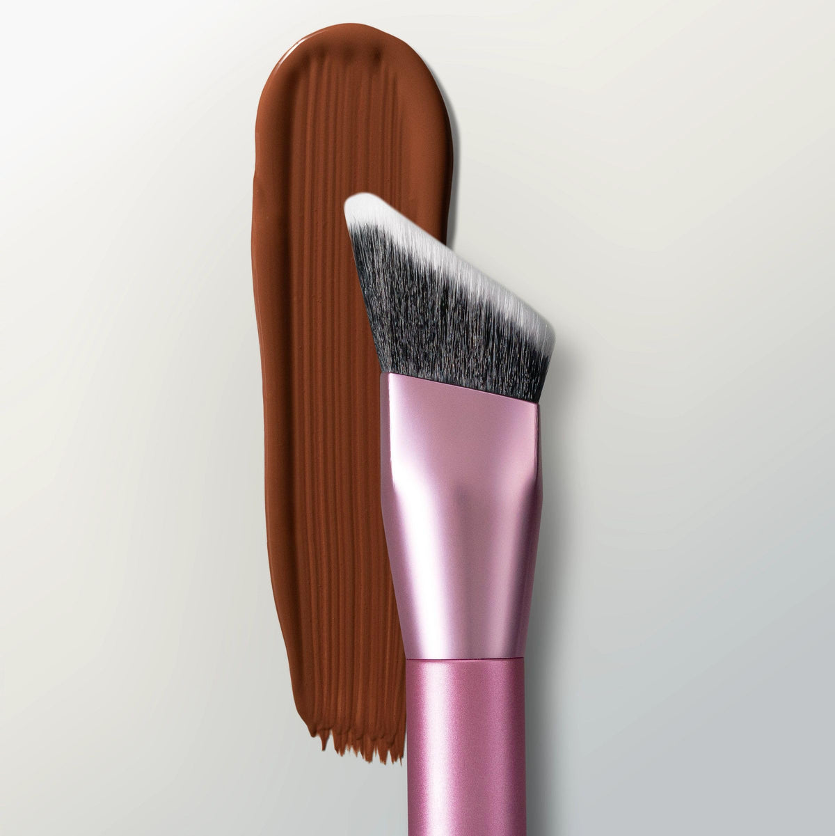 Real Techniques brush next to liquid bronzer demonstrating product pickup