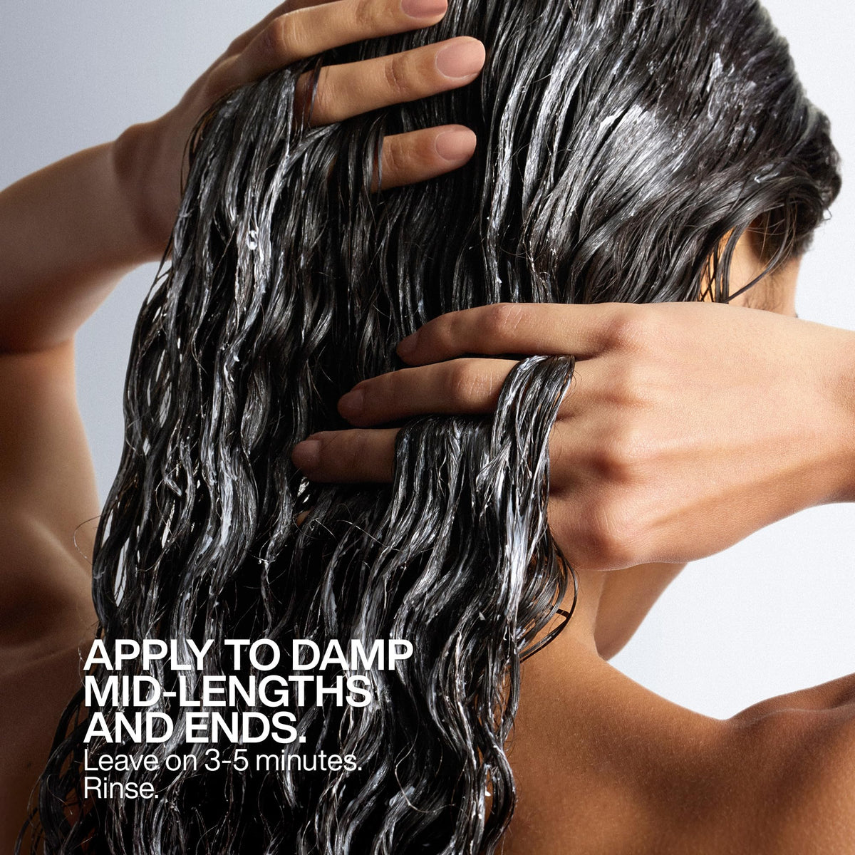 Hand holding Redken All Soft jar showing true size and travel-friendly benefit