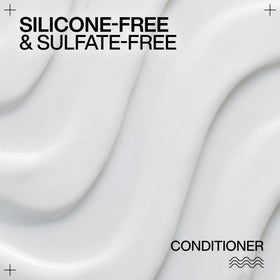 Redken conditioner being applied for even distribution and improved curl pattern