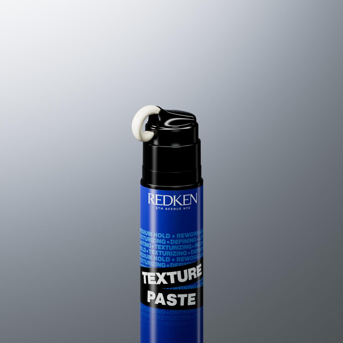 Redken jar beside a ruler showing size for travel-friendly convenience