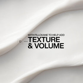 Redken creamy conditioner texture on hand, demonstrates lightweight spreadability