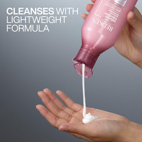 Redken 33.8 fl oz bottle next to a hand for size comparison and value