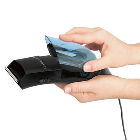 Remington clippers in use during self-haircut capturing trimmed hair for convenience