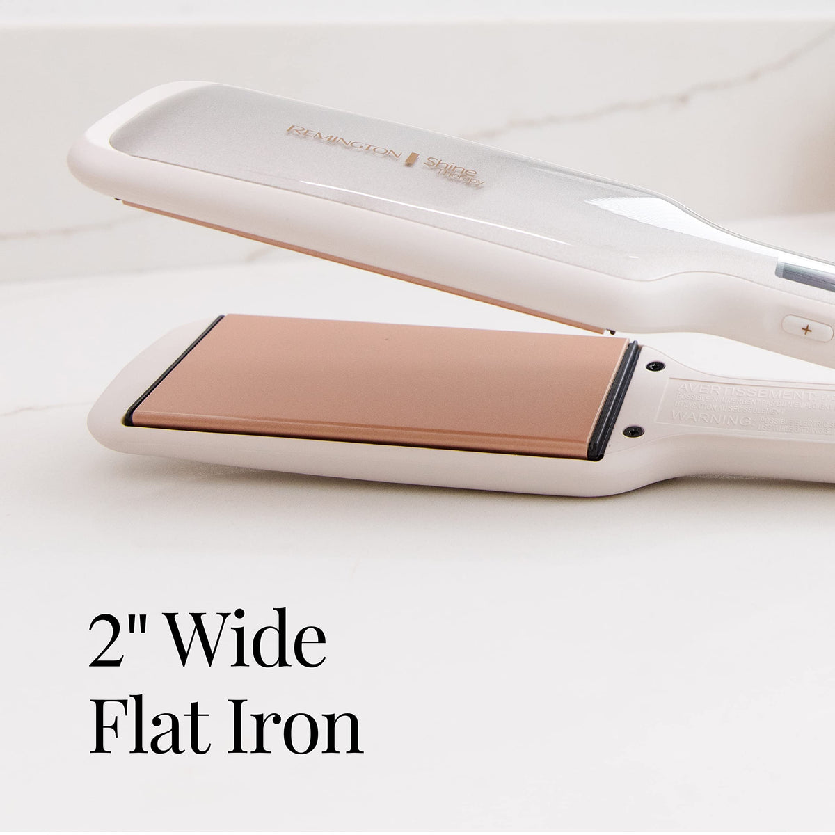 Remington flat iron next to hand to show 2-inch plate scale and travel convenience