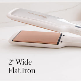 Remington flat iron next to hand to show 2-inch plate scale and travel convenience