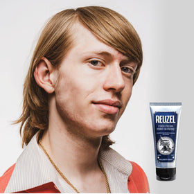REUZEL jar in barbershop setting showing professional styling benefit