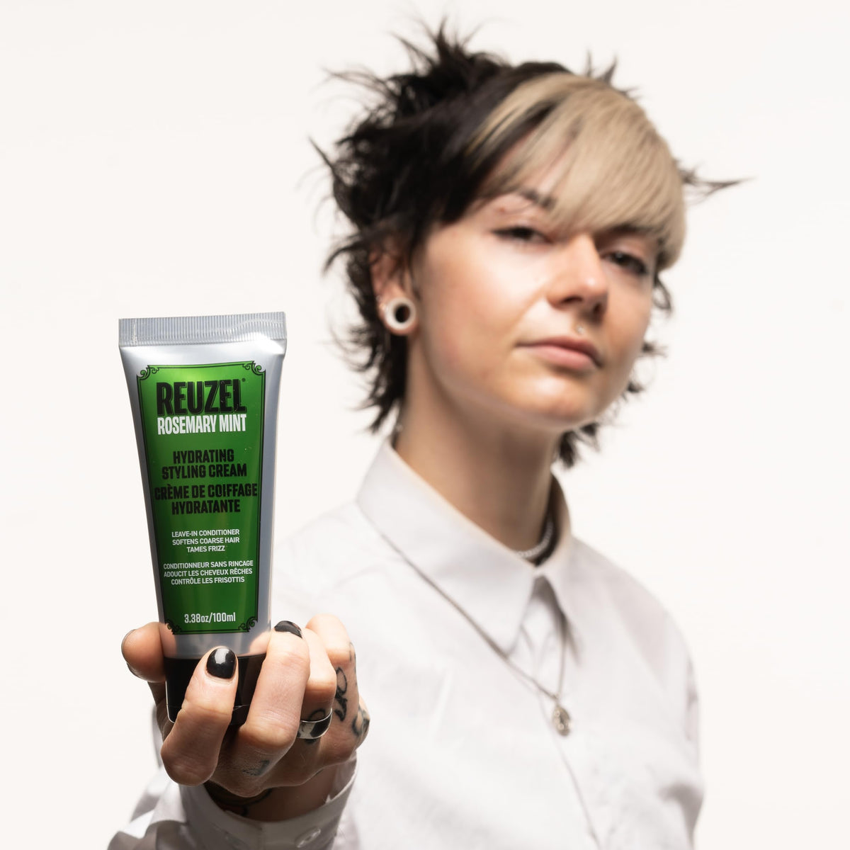 REUZEL being smoothed through damp hair showing frizz control and manageability