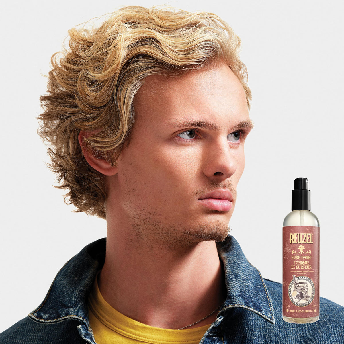 REUZEL bottle beside pomade and clay to show layering options and styling versatility