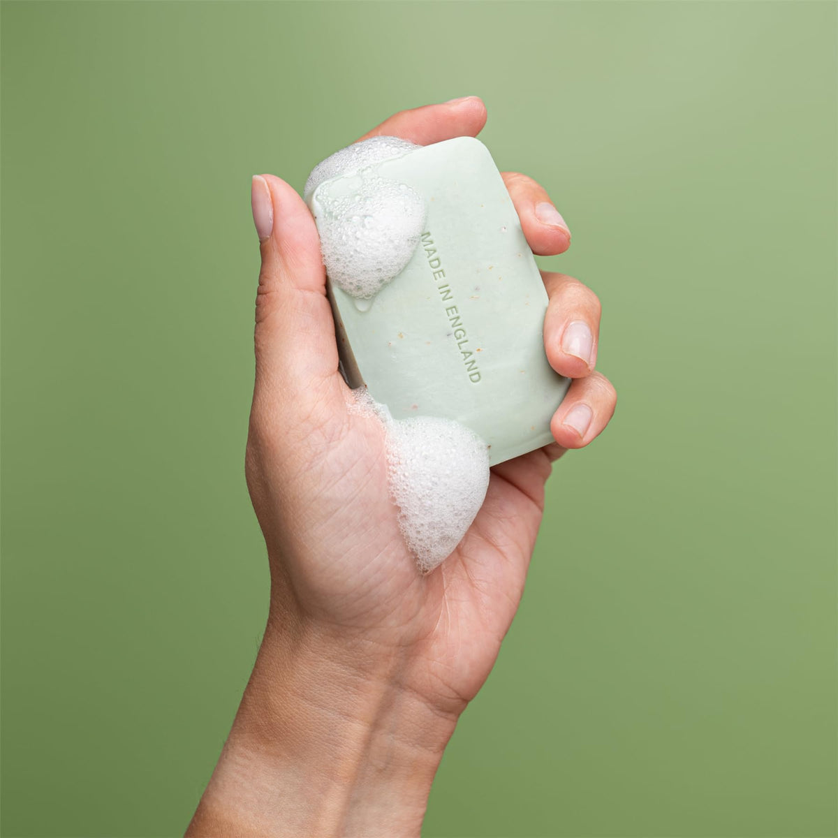 REVITALE soap held in hand to show actual bar size and travel-friendly scale