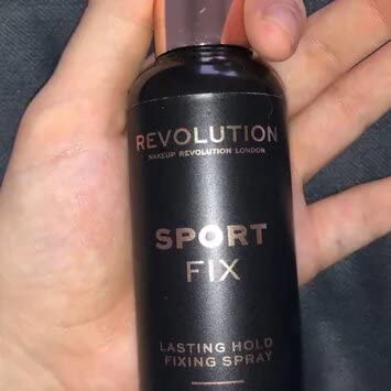 Revolution Beauty London bottle in hand showing travel-friendly size and portability