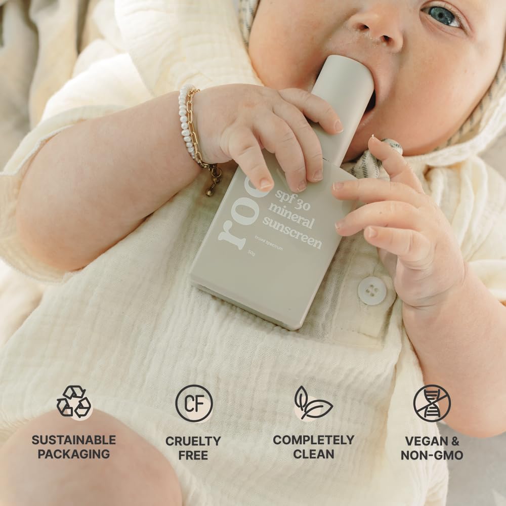 Roe Wellness bottle on sand near water symbolizing reef-safe ocean-friendly sunscreen